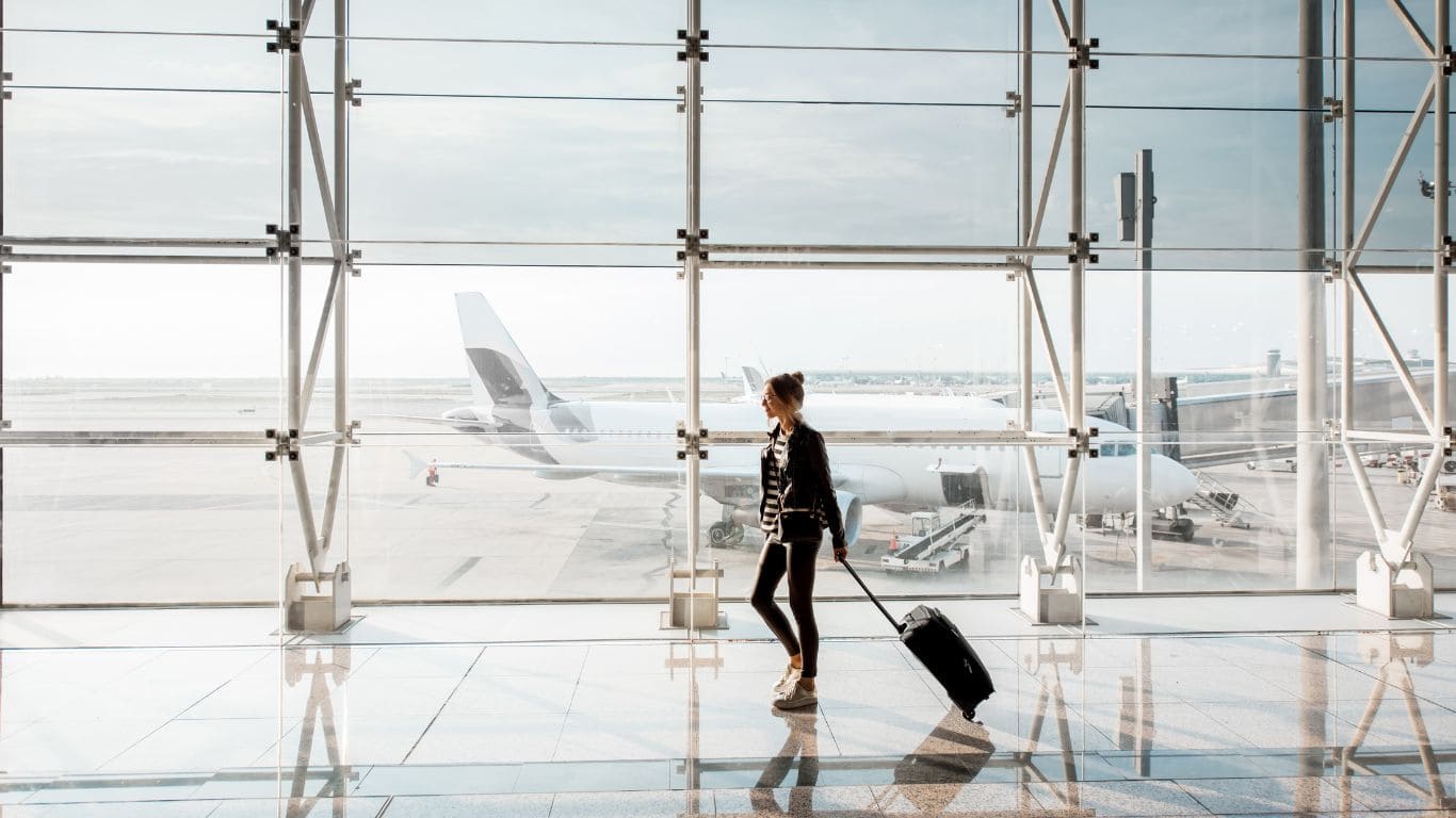 Chica caminando por el aeropuerto con maleta