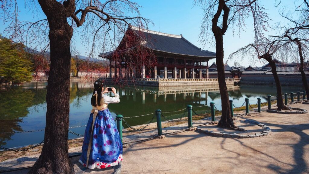 Chica con traje tradicional haciendo foto al Palacio Gyeongbokgung