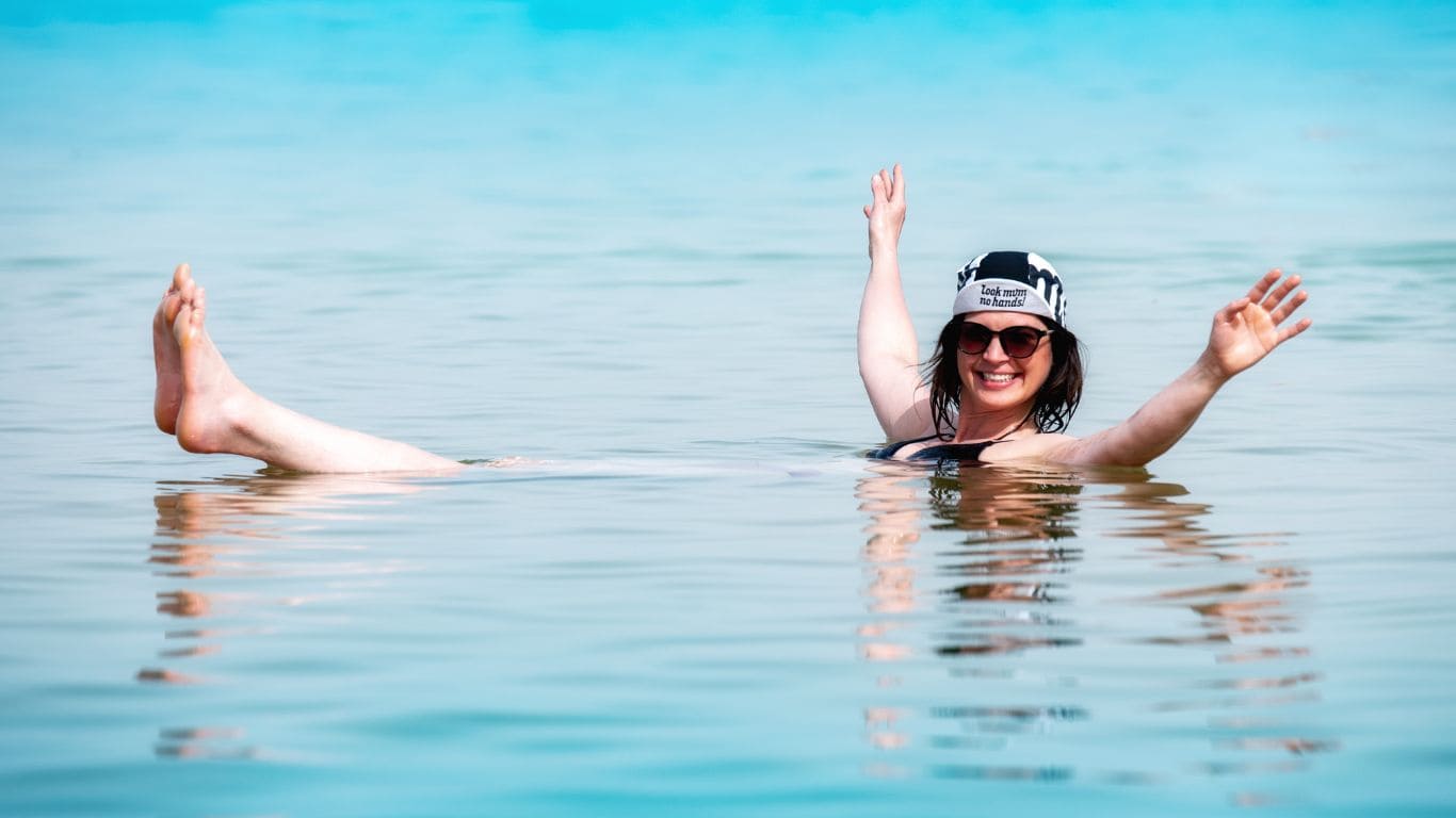 Chica dándose un baño en el mar muerto flotando